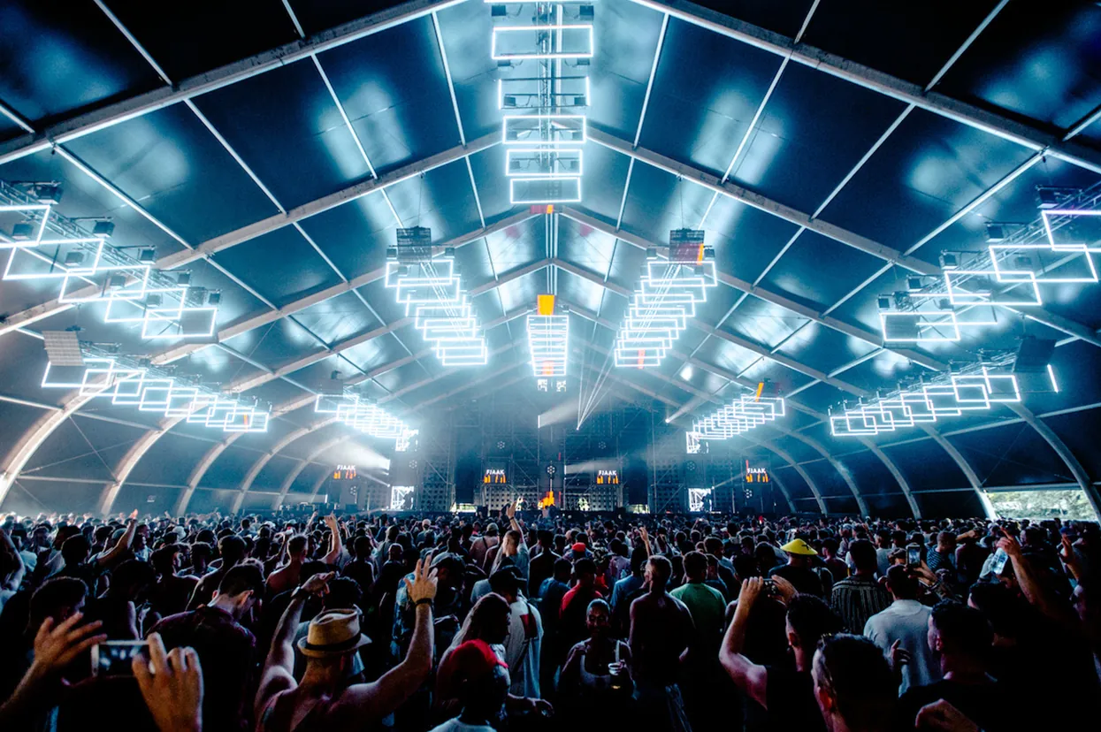 Crowd under a vaulted roof filled with lighting trusses