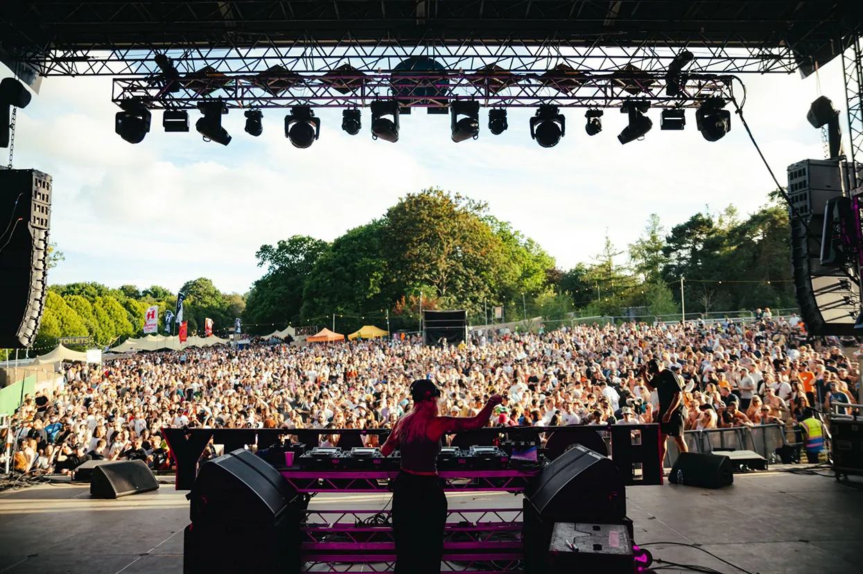 Outdoor stage with a large crowd at dusk