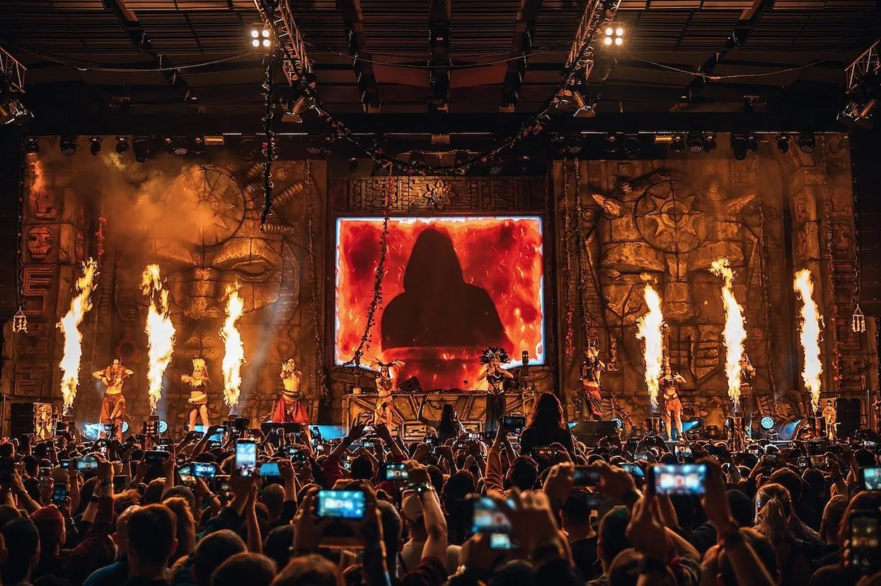 Main stage set with flame jets and a full house filming