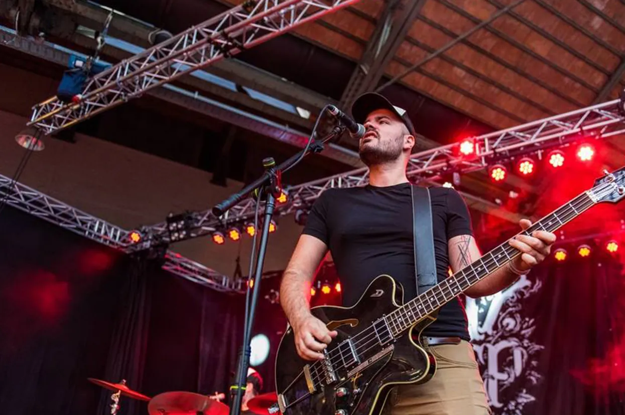 Guitarist playing under red stage lighting