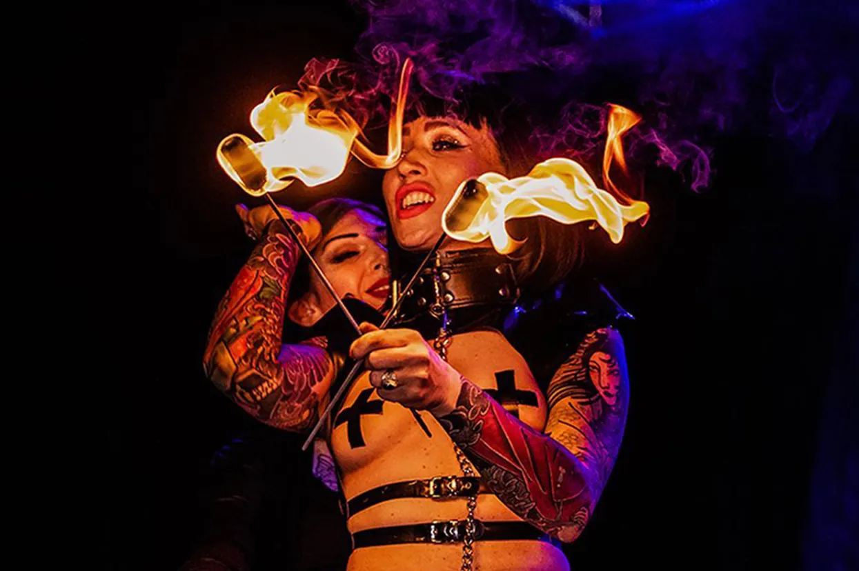 Two fire performers holding lit torches